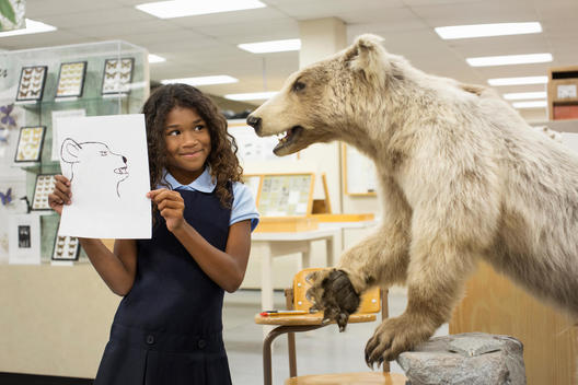 Student holding drawing of bear in museum