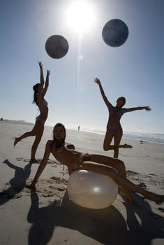 Friends Playing With Exercise Balls On Beach