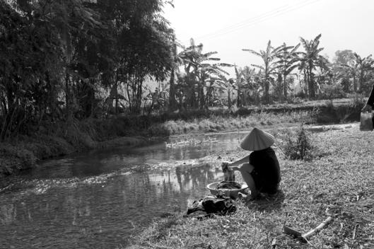 A Local Woman Washes Her Clothes In The River In Mai Chau Valley, Vietnam