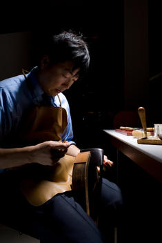 Leather Workman Artisan Working On Leather Stitching For Hermes