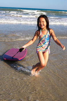 gril running out of the water with a surf glide