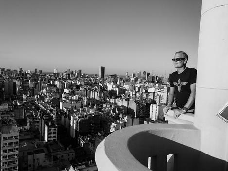 A man on the deck of a building overlooks an overview of the city of Buenos Aires.