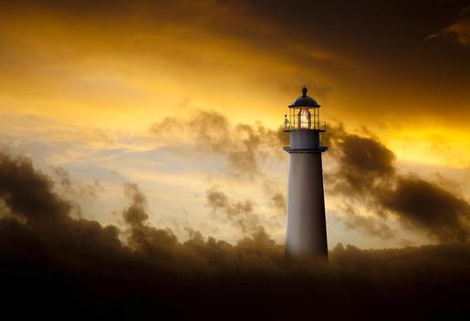 Lighthouse glowing under dramatic sky