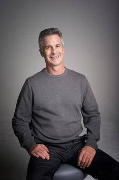 Handsome man in his 60\'s wears a grey sweater.