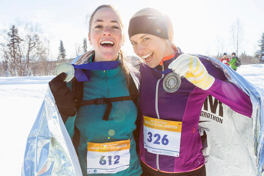 Winner and runner up of woman\'s winter running race show their medals