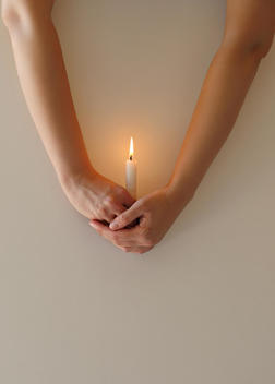 Hands holding a candle.