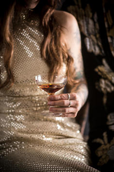 Caucasian woman in evening gown drinking cocktail