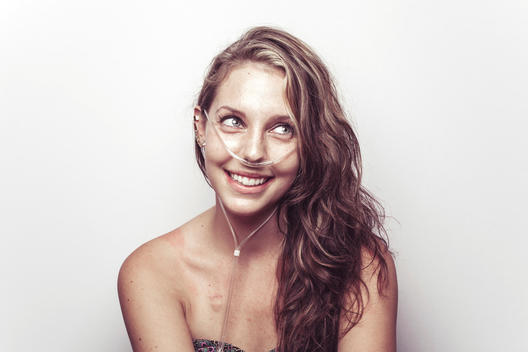 Smiling, beautiful young woman wearing oxygen for breathing, Cystic Fibrosis patient