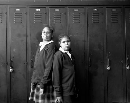 School girls in uniform standing by lockers