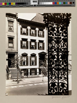 Houses side by side with decorative wrought iron in the foreground.