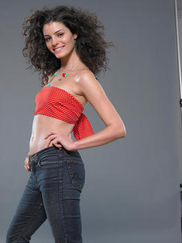 brunette wearing red tube top scarf, jeans and necklace in studio