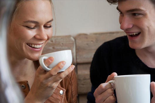 Two young people having a coffee, laughing