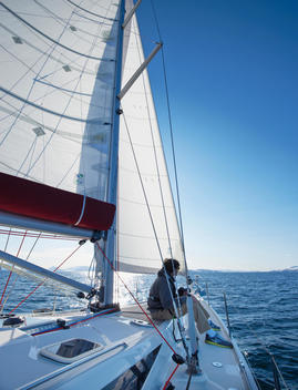Man sitting on sailing yacht in fjord