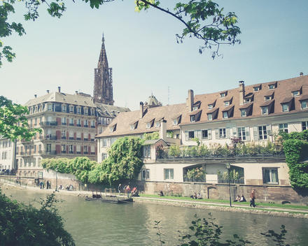 France, Alsace, Strasbourg, L'ill River, View of waterfront and Strasbourg Cathedral tower