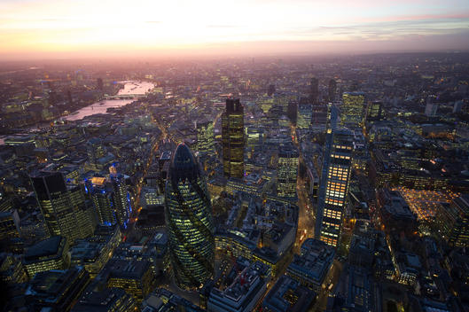 Aerial View Over City Of London ( The Square Mile ) At Sunset. Swiss Re Tower In Foreground.