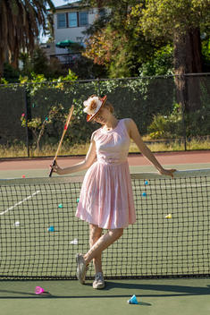 girl leaning on net holding badminton racquet