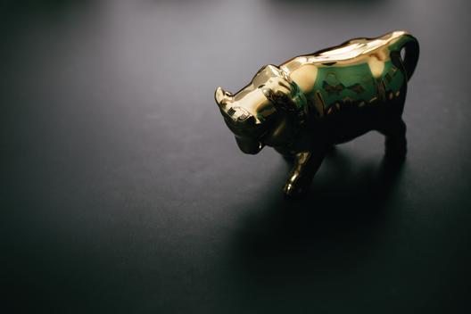 Still life of golden bull as symbol for the stock market (bull power) in a buying market period.