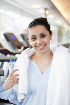 Woman With Towel And Water Bottle In Gym