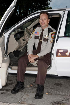 A Rice County Police Officer Poses For A Portrait In His Patrol Car.
