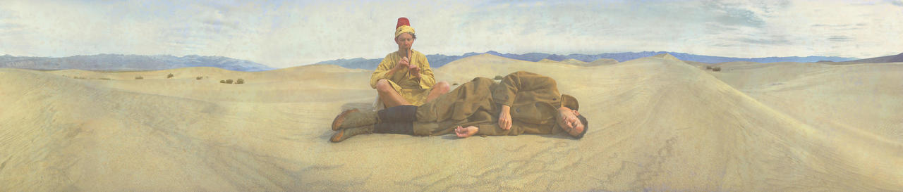 Man Plays A Flute While Another Man Sleeps In The Desert