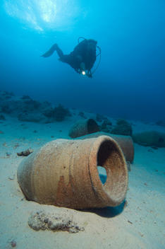 Egypt, Red Sea, Scuba diver and amphoras on ocean bed