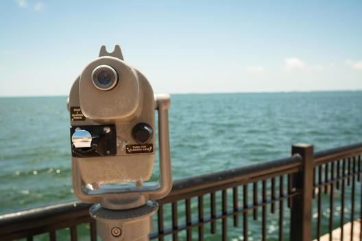 Coin operated binoculars overlooking a scenic water view.