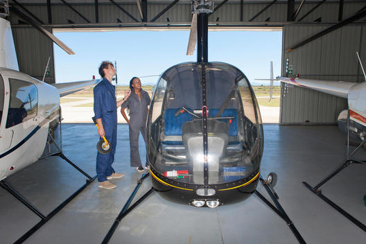 Student pilots checking exterior of helicopter