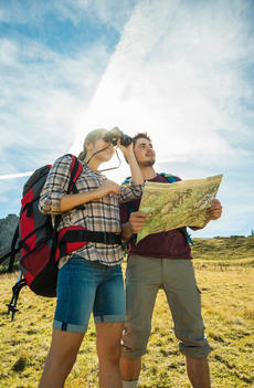 Austria, Tyrol, Tannheimer Tal, young couple hiking with map and binocular