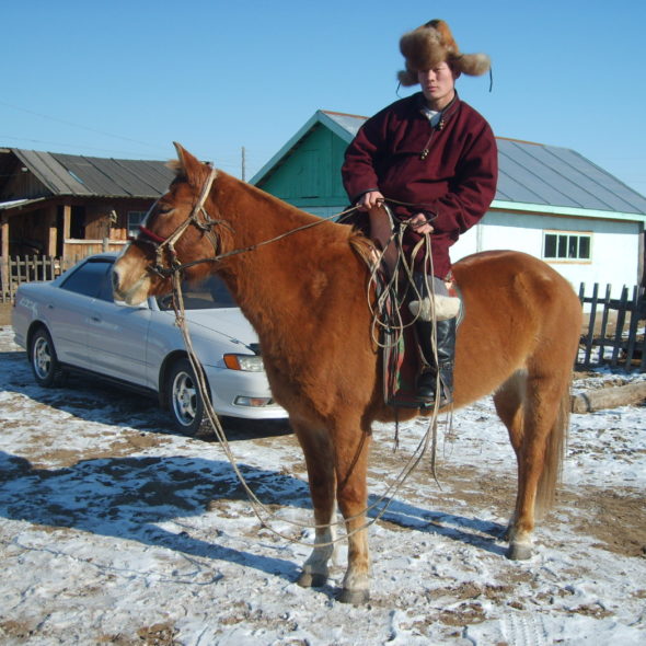 Mongolian man riding a horse