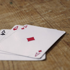 Three Aces Cards On Wooden Table