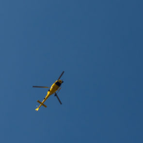 Yellow helicopter against the blue sky