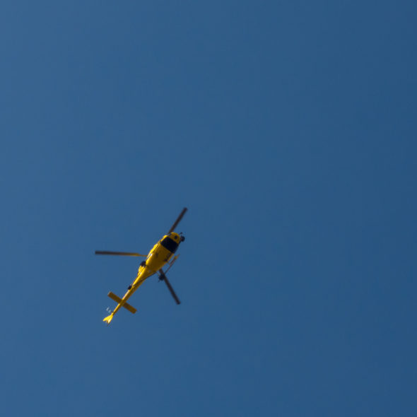 Yellow helicopter against the blue sky
