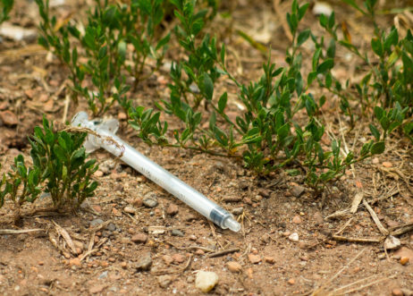 Hypodermic Syringe On The Ground