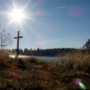 Sun over the lake and a crucifix