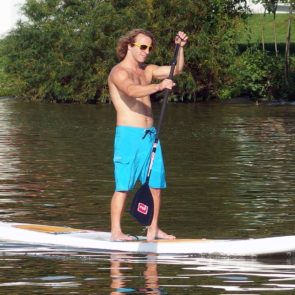 Man Stands at Paddle Board