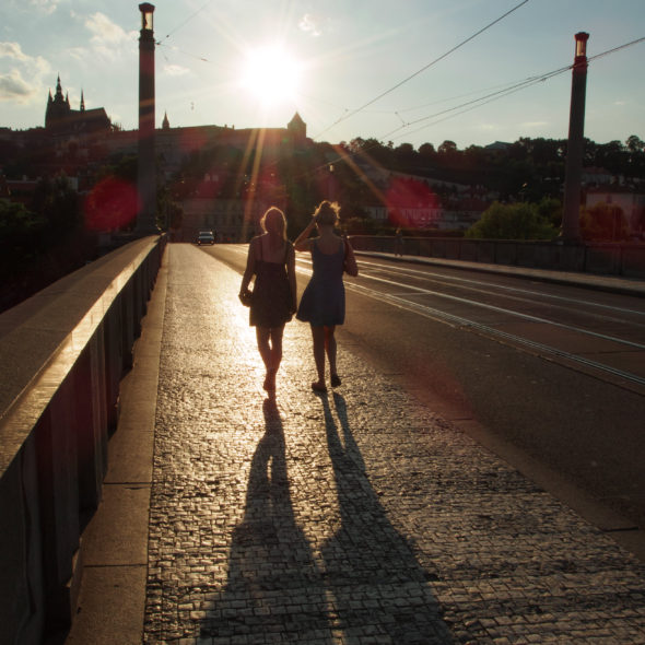 Two tourists – girls walking on the Prague bridge
