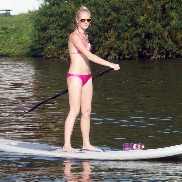 Woman Stands at Paddle Board