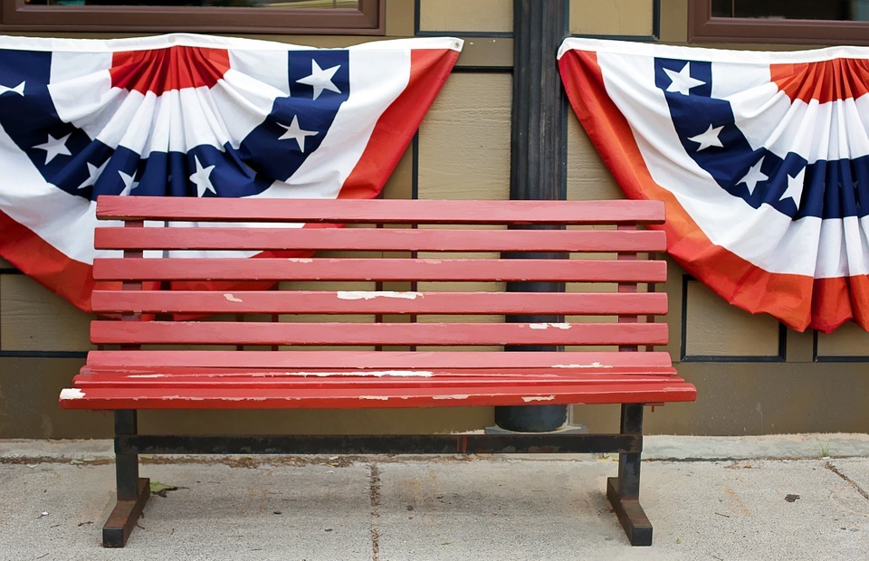 american flags, bunting, red bench