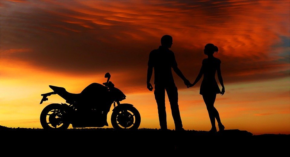 motorcycle couple holding hands