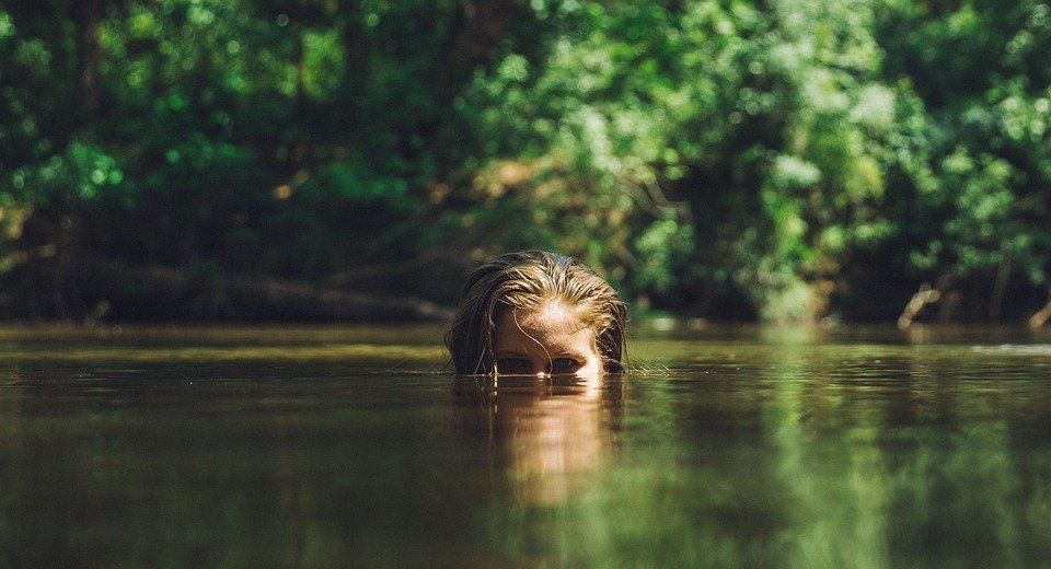 portrait of a little girl with long hair in the lake.